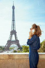 tourist woman against Eiffel tower talking on smartphone