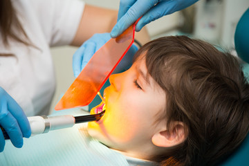 Boy at a dentist office, new teeth examination and treatment of cavities