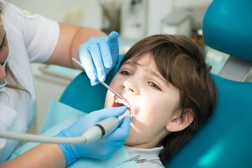 Boy at a dentist office, new teeth examination and treatment of cavities