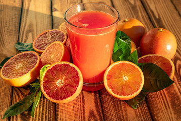 Red  Blood Oranges Juice With Fresh Fruits On Wooden Background.Outdoor Shot In The Sunshine