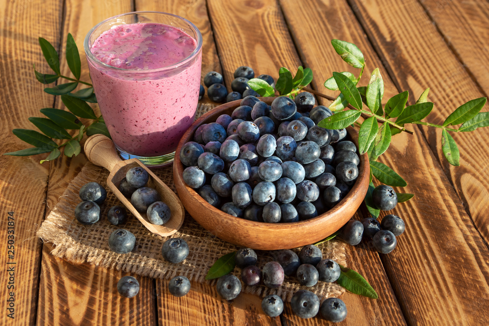 Wall mural Blueberries smoothie with fresh berries on wooden background