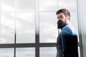 modern life. business man standing at window with cityscape. Brutal bearded man. Mature hipster with beard. Male in modern business office. Businessman in formal suit. Modern life of businessman