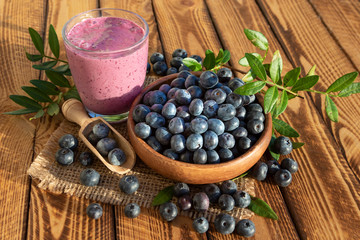 Obraz na płótnie Canvas Blueberries smoothie with fresh berries on wooden background