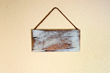An old blank wooden sign hanging on a wall indoors. with copyspace.