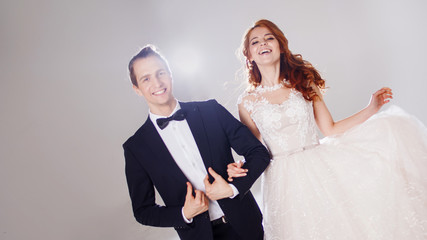 Happy young couple laughing and dancing together. The couple in the Studio a light background.