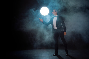 Fototapeta premium lonely Young man in a suit pulls his hand somewhere and waits for someone