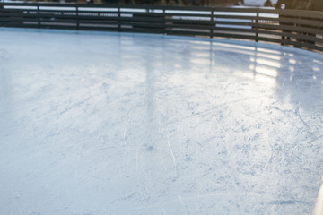Texture of ice on ice rink, ice patterns, riding in the rink, outdoor ice rink, marks from skating and hockey/ selective focus on the foreground,  frozen lake/ winter, sport and leisure concept.