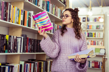 Serious concentrated girl carrying opened book in raised hand