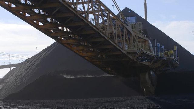 Coal terminal stacker reclaimer lifting coal pile slow motion