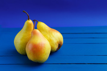 Pear decoration stock images. Yellow pear on blue background. Pear home decor. Yellow decorative...