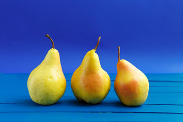 Fototapeta na wymiar Pear decoration stock images. Yellow pear on blue background. Pear home decor. Yellow decorative pear