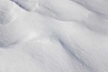 High angle view close up of snowdrift on a sunny and windy winter day