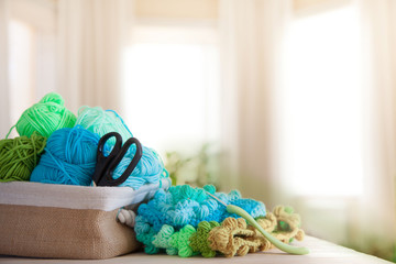 Women's hobby. Needlework and crocheting and knitting. Bright yarn. Concept of women's leisure.