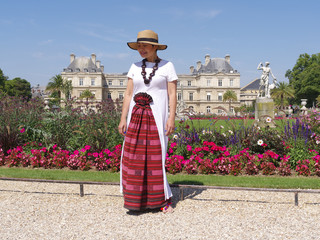 Femme posant devant les parterres et le palais du Luxembourg à Paris