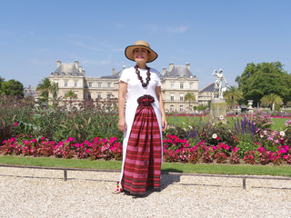 Femme posant devant les parterres et le palais du Luxembourg à Paris