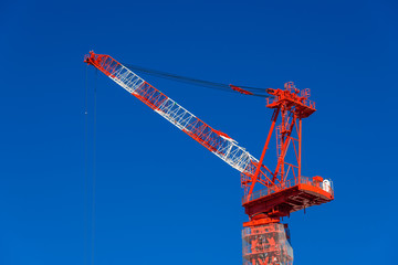 Construction fixed crane at work against a blue sky