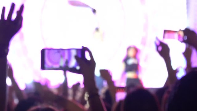 Blurred Concert Crowd at Music Festival. Crowd people dancing Rock concert, weighted, applause, raises his hands up and photographed, filmed concert on the phones and smartphones. 