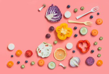 Colourful different cut raw vegan food and empty text space book page on pick background.