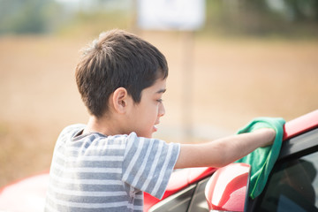 Fototapeta premium Little boy cleaning car