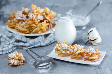 cookies brushwood with powdered sugar and jug of milk