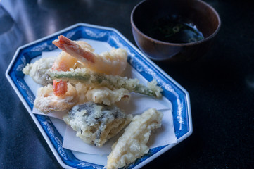 Tempura prawns and fish served with soy sauce in Japanese restaurant
