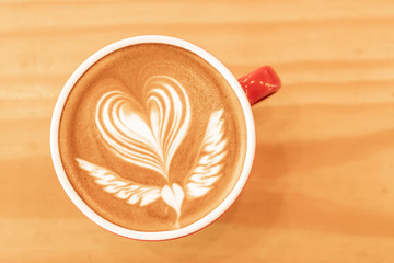 Hot art coffee cappuccino in a cup on wooden table background  with copy space