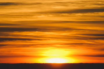 Fototapeta premium The sun rises from the horizon in the morning, with layers of clouds