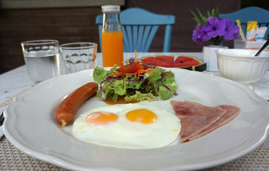 American breakfast serving with fried egg, ham ,sausage and salad