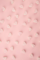Tasty heart shaped pink marshmallows on color pink background, pattern, monochrome sweetness background, copy space