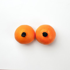 Natural organic exotic citrus fruit and dry grapes as a woman's breast, bust with copy space.