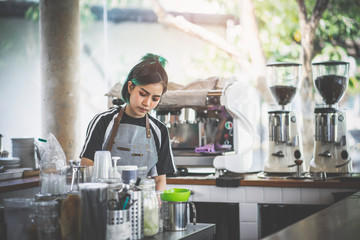 Asian cute barista making coffee in the coffee shop