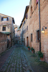 Cosy narrow medieval street in Certaldo old town with stone pavement, Tuscany, Italy