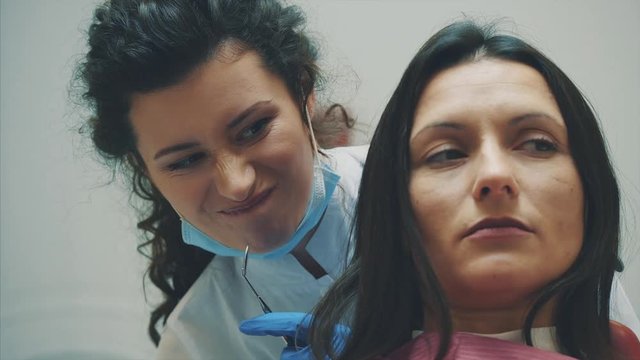 A young girl is admitted to a dentist. During this time she opens her mouth and understands the doctor.