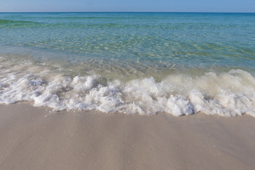Fototapeta na wymiar Emerald ocean crashing in on sandy beach