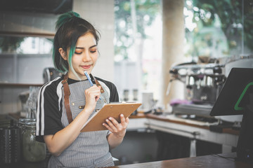 Asian cute barista making coffee in the coffee shop