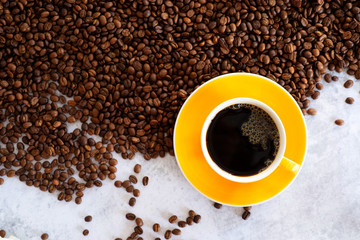 fresh coffee in yellow cup on rosted coffee bean background