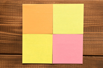 Different colored stickers on a wooden background. Empty text space
