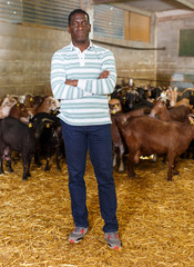 African-American man with arms crossed in goat stall