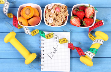 Healthy food, dumbbells, tape measure and notebook for notes, slimming, healthy and sporty lifestyle concept
