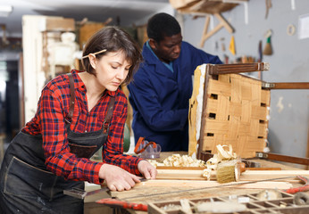 Artisans in process of renewing armchair