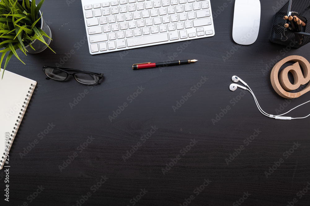 Poster flat lay of top view modern black wood desk work table with computer laptop and stationary in home o