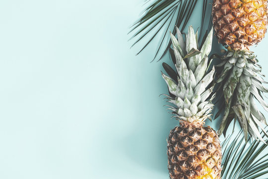 Summer composition. Pineapple, palm leaves on pastel blue background. Summer concept. Flat lay, top view, copy space