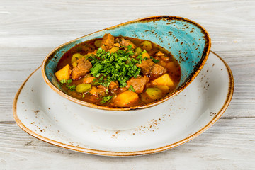 Soup with pickles and meat shot on wooden background