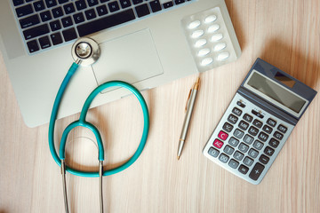 Stethoscope and Calculator on Doctor Office Table., Table Workspace Desktop for Examining Patient Health., Business Healthcare Insurance and Medicine Concept.