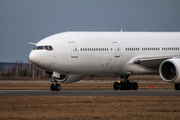 Close-up taxiing white wide body passenger airplane