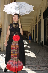 femme avec ombrelle blanche marchant sous les arcades du palais royal à Paris