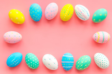 Colorful Easter eggs frame on pink background top view space for text