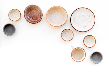Ceramic tableware pattern. Empty plates and mugs on white background top view copy space