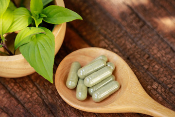 Herbal capsules with with sweet basil fir healthy eating 