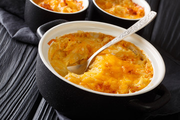 Homemade potato casserole with sour cream, onions and cheddar cheese close-up in a pan. horizontal